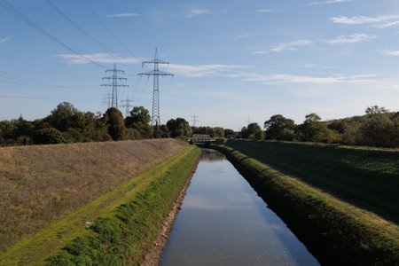 Water channel with power lines, bypass channel for big river. Sunny day and clouds on the sky.の写真素材