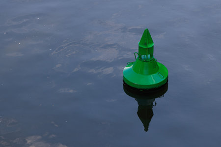 Green buoy floats on the water. It is the navigation sign for boats.の写真素材