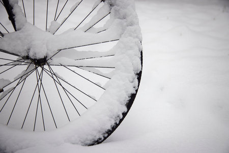 Wheel of a parked bicycle in winter.の写真素材