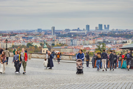 An observation deck on Prague with a view of the autumn city of Prague and people on it.