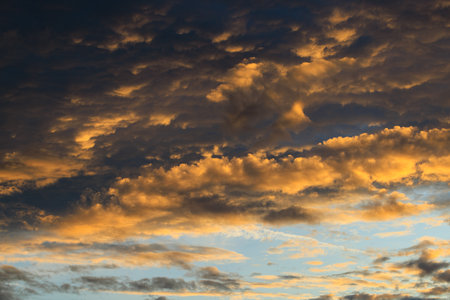 Beautiful sunset sky above clouds with dramatic yellow light.の写真素材