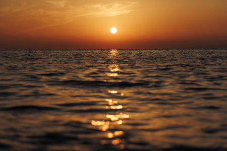 Calm sea at orange sunset, view from the bottom.の写真素材