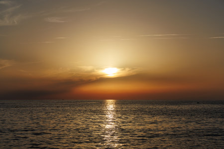 Orange sunset in the sea with sunny pathway.の写真素材