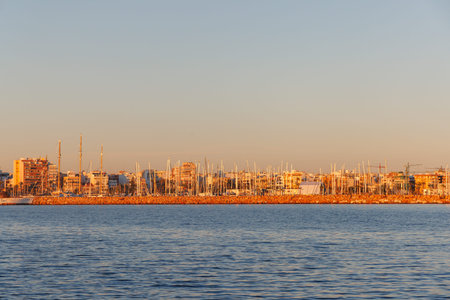 View of the masts of yachts moored in the port of Torrevieja at sunset.の写真素材