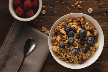 A white bowl with cereals and fruits