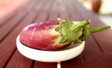 Two eggplants ( aubergine ) on white plate, outdoor.の写真素材