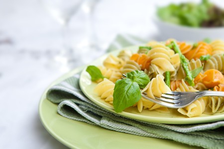 Colorful pasta with asparagus and rocket pesto and basilの写真素材