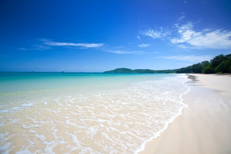 Beautiful white sandy beach with crystal clear blue water and blue skyの写真素材
