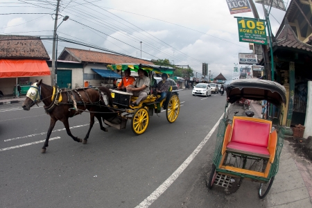 JOGJAKARTA 15th MAY. Horse drawn carriages are popular method of transportation in the busy streets of Jogja. A family on a horse drawn carriage in the streets of Jogjakarta on 15th May 2010.のeditorial素材