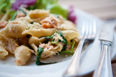 Pasta with salmon, spinach and cream, with fresh salad on the side の写真素材