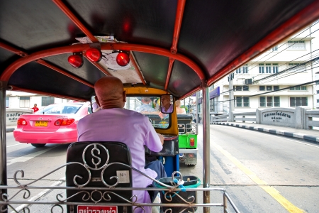 BANGKOK, THAILAND  - AUGUST 2010.  A tuk tuk negoting a back street in the busy town of Bangkok,  Jan 20, 2010.  These are motorized rickshaws and are popular amongst tourists for their novelty value. のeditorial素材