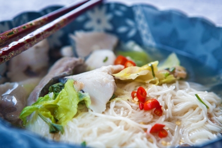 Delicious fish soup with noodles and lettuceの写真素材