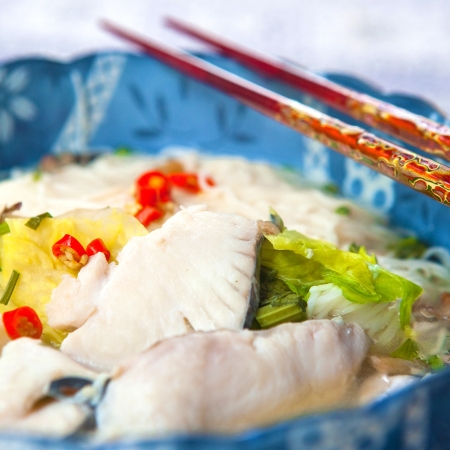 Delicious fish soup with noodles and lettuceの写真素材