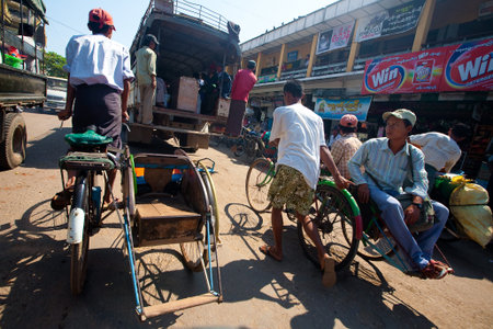 PATHEIN MYANMAR - JAN 30. Trishaw operator ferrying locals from market, 30 Jan 2010, Pathein,...