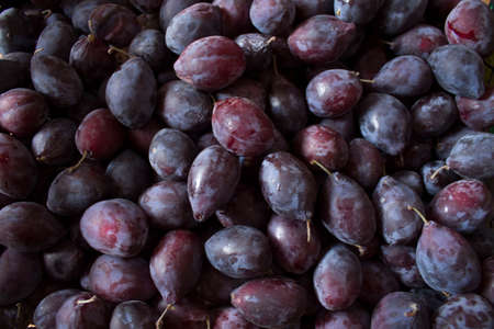 Close up of fresh plums with leaves, top viewの写真素材
