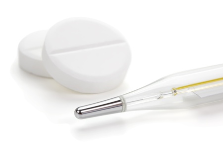 Close-up medical thermometer and tablets isolated on the white background.の写真素材
