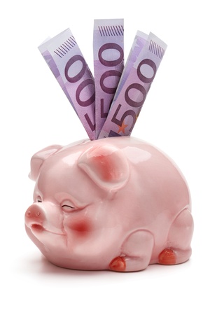 Pink piggy bank with five hundred euro banknotes, isolated on the white backgroundの写真素材