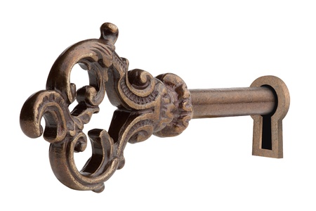 Vintage key in keyhole, isolated on the white background, clipping path included.の写真素材