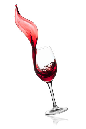 Red wine splashing from glass, isolated on the whiteの写真素材