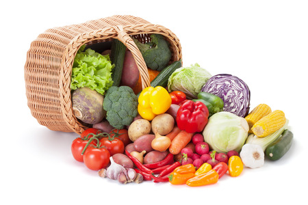 Fresh vegetables next to the overturned basket, isolated on the white background.の写真素材