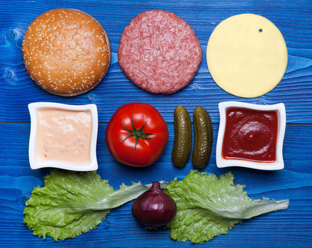 Ingredients for hamburger on blue wooden table.の写真素材
