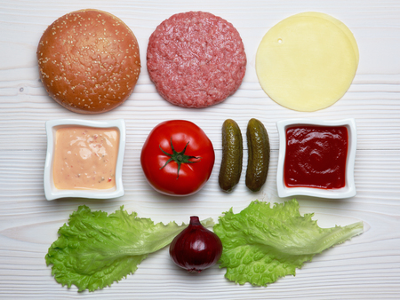 Ingredients for hamburger on white wooden table.の写真素材