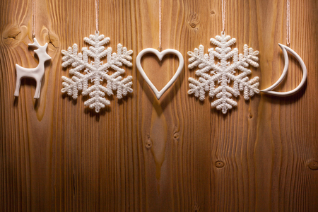 White Christmas decorations hanging on wooden wall. Background with space for text.の写真素材