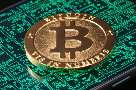 Golden bitcoin on the smartphone screen with abstract digital background.の写真素材