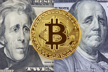 Golden bitcoin on dollar bills background with puzzled faces of American presidents.の写真素材