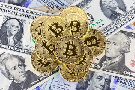 Golden bitcoin coins on dollar bills background.の写真素材