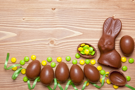 Easter chocolate eggs, bunny and candies on wooden background.の写真素材