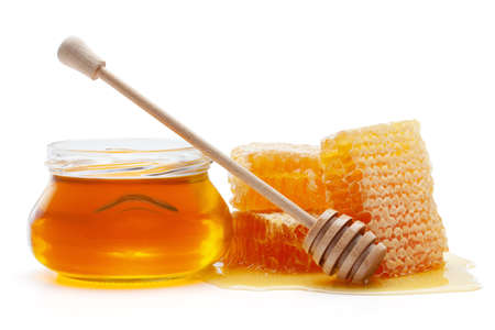 Honey in glass jar with wooden dipper and honeycombs, isolated on the white background, clipping path included.の写真素材