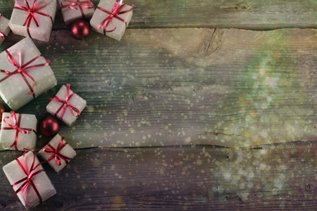 Christmas background with decorations and gift boxes on wooden board