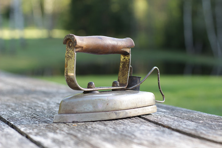 Old electrical iron on an old wooden tableの写真素材