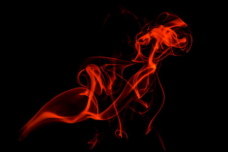 Abstract red smoke swirls over black background