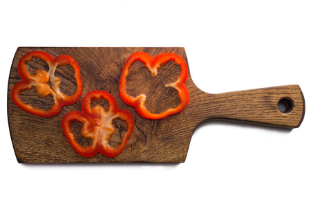Sliced sweet pepper on wooden board on white backroundの写真素材