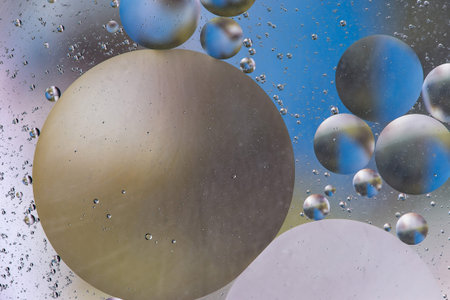 colorful oil bubbles on a water surface abstract background with blue color