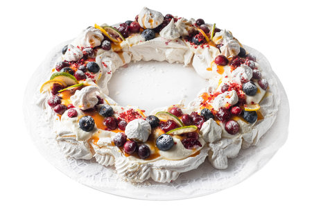 Meringues pavlova cake wreath with cherry, blueberry, lemon, cranberry and lime, top view.