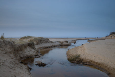 Peaceful river flowing through a sandy landscape towards the horizon. Tranquil and serene nature...