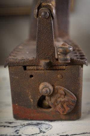 Rusty Vintage Iron with Wooden Handle Sitting on old Tableの写真素材