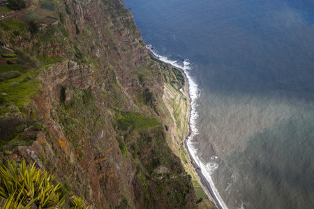 Visitors can marvel at the Cabo Girao Skywalk, which offers panoramic views of Madeira's dramatic cliffs and ocean. The glass platform enhances the experience by providing a unique perspective.の写真素材