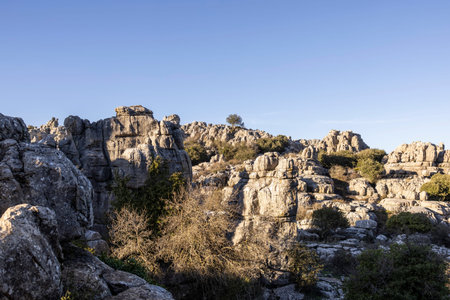 Visitors hike the rock formations of El Torcal in Spain. The scenery features unique stone shapes...