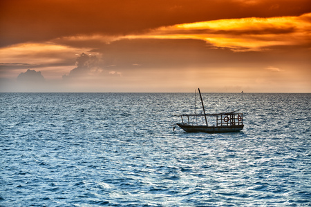 Typical dhow swings in sea at sunset, Zanzibar, Tanzania, Africaの写真素材