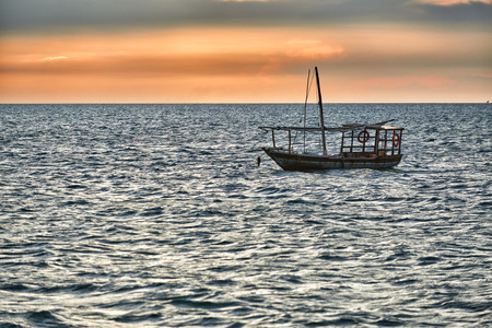 Typical dhow swings in sea at sunset, Zanzibar, Tanzania, Africaの写真素材