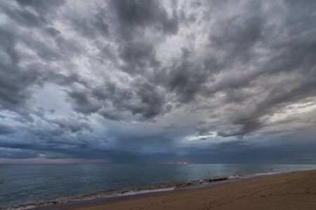 Dramatic, cloudy sky, sunset on the beach of Atlantic ocean in Portugalの写真素材