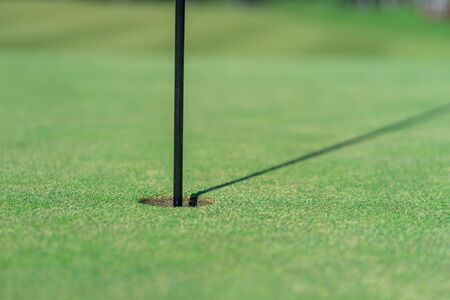 Close up of golf hole, golf flag and green grassの写真素材
