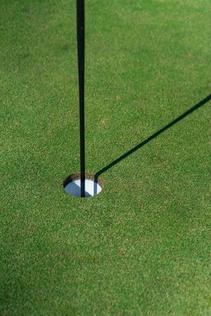 Close up of golf hole, golf flag and green grassの写真素材