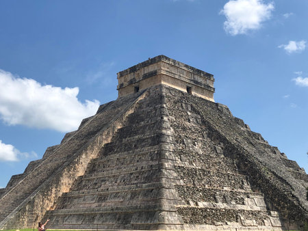 Kukulcan Pyramid with a blue sky and some clouds in Chichen Itza, Yucatan, Mexico