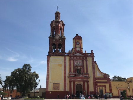 Church with a tower in Cadereyta, Queretaro, Mexico with a tree and a blue sky