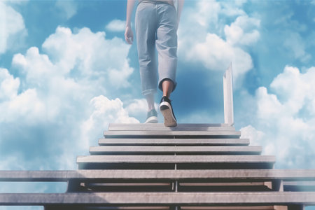 Low section of woman walking up stairs against blue sky with white cloudsの素材